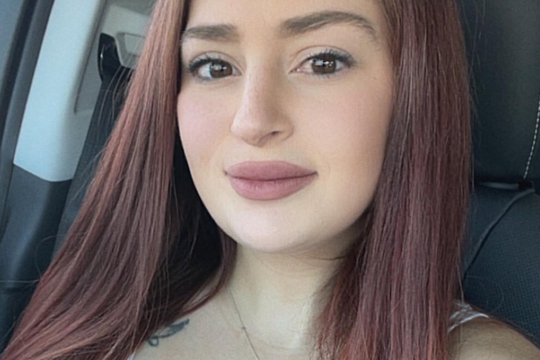 Woman with long red hair sitting inside a vehicle